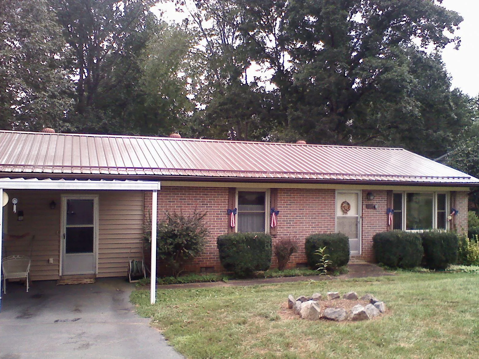 Bronze metal roof and carport on a brick ranch home — Roof Repair work by our crew in Mico